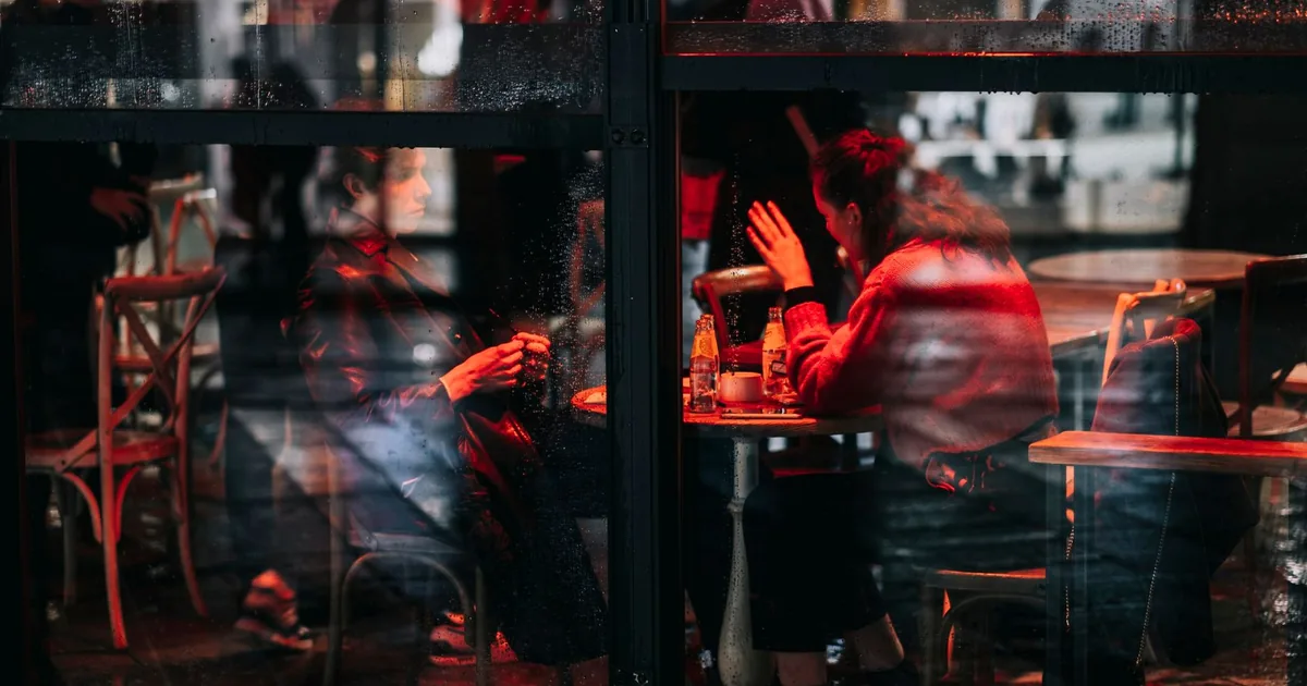 Casal à distância em uma mesa de restaurante, a cena por trás de quanto um detetive cobra para descobrir uma traição